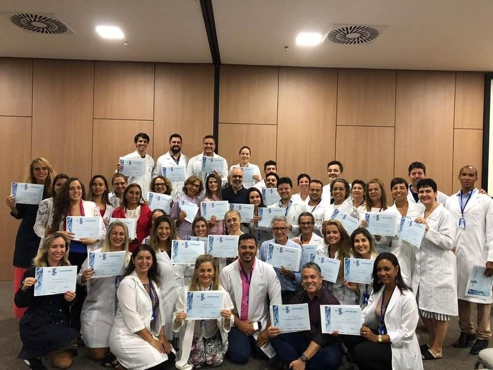 Grande turma de profissionais exibindo seus certificados